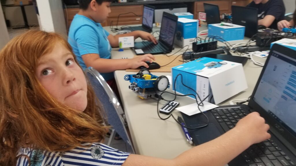 Young girl programming her robot